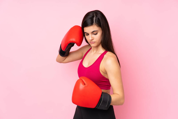 Młoda kobieta sport na odizolowanym różowym tle z rękawicami bokserskimi - Zdjęcie, obraz