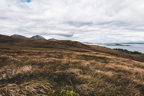 Panorama-Luftaufnahme der Ufer, Berge und Täler der Insel Jura. Bewölkter blauer Himmel. Stürmisches Wetter. Landkarten von Jura, Innere Hebriden, Schottland, Großbritannien. Reiseziele, Tourismus, nationale Sehenswürdigkeiten - Foto, Bild