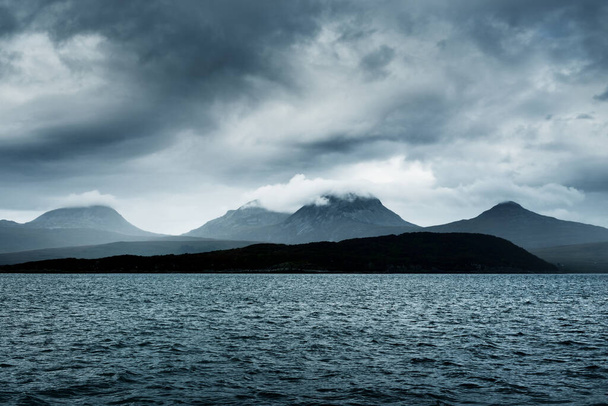 Blick vom Wasser auf die Ufer, Berge und Täler der Insel Jura. Bewölkter blauer Himmel. Stürmisches Wetter. Landkarten von Jura, Innere Hebriden, Schottland, Großbritannien - Foto, Bild