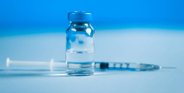 Closeup syringe and ampoule on blue background - Photo, Image