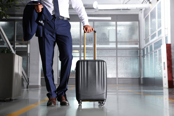 Businessman with black travel suitcase in airport. Space for text - Foto, Bild