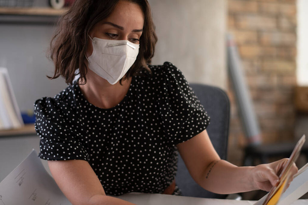 woman working at office, wearing protective mask - Фото, изображение