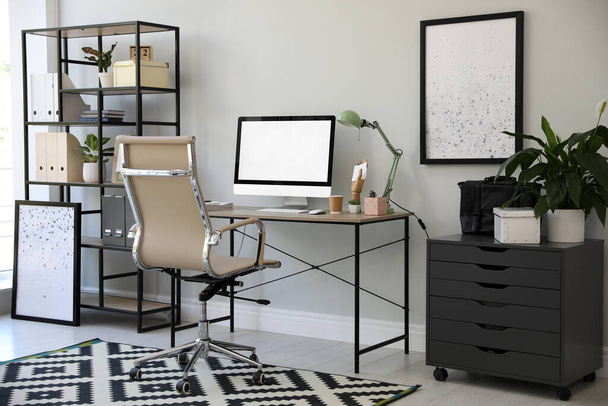 Comfortable office chair near desk with modern computer indoors - Fotoğraf, Görsel