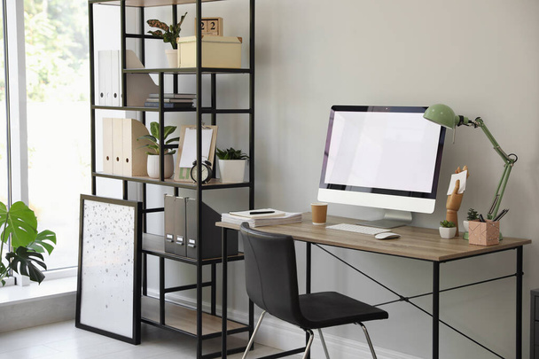 Comfortable office chair near desk with modern computer indoors - Фото, зображення