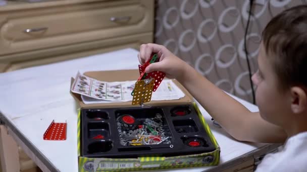 Curious Boy plays with Metal Parts of Constructor on Table at Home. Slow-motion - Footage, Video