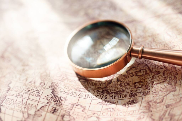 Retro copper colored magnifying glass and old white nautical chart close-up. Vintage still life. Sailing accessories. Travel, navigation concepts, collecting, graphic resource, hand lens, optics - Photo, Image