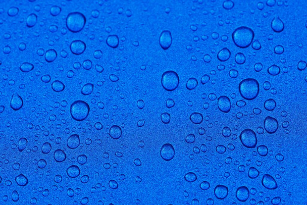 Яркий синий фон, кристально чистые капли (капли дождя). Абстрактный шаблон, обои, концепт-арт. Блеск, текстура краски. Графические ресурсы, дизайн, 3D, макрофотография, окружающая среда, очистка воды - Фото, изображение