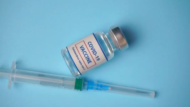 I vaccini Coronavirus covid ruotano su uno sfondo blu in un laboratorio medico. Vaccinazione, protezione sanitaria dalla pandemia di coronavirus. - Filmati, video