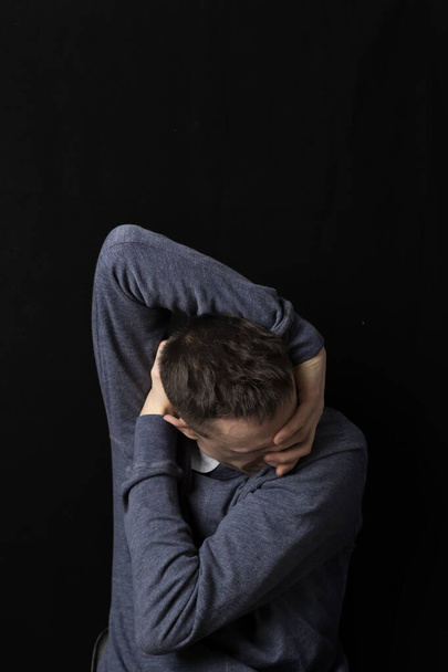Psychische Gesundheit. Ein Mann in depressivem Zustand vor schwarzem Hintergrund. Trauriges Männchen. - Foto, Bild
