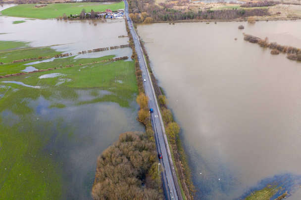 Foto aérea del dron de la ciudad de Allerton Bywater cerca de Castleford en Leeds West Yorkshire mostrando los campos inundados del río Aire en un día lluvioso de invierno durante una gran inundación después de una tormenta. - Foto, imagen