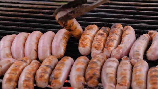 Slow motion: chef grilling fresh meat sausages on big round hanging grill - Footage, Video