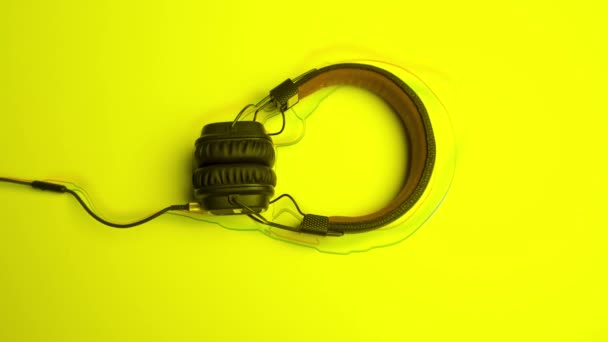Ακουστικά σε έγχρωμο φόντο με γραμμές. Κινούμενα σχέδια. Νέα ακουστικά βρίσκονται σε έγχρωμο φόντο με κινούμενες γραμμές. Κινούμενες γραμμές ακολουθούν το σχήμα των ακουστικών - Πλάνα, βίντεο