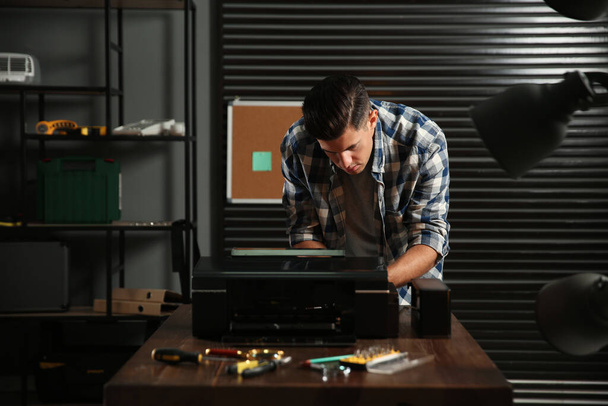 Professional repairman fixing modern printer in office - Фото, зображення