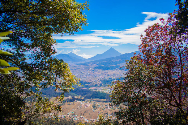stromy s krajinou a výhledem na sopku Santa Maria s městem v údolí Quetzaltenango - Fotografie, Obrázek
