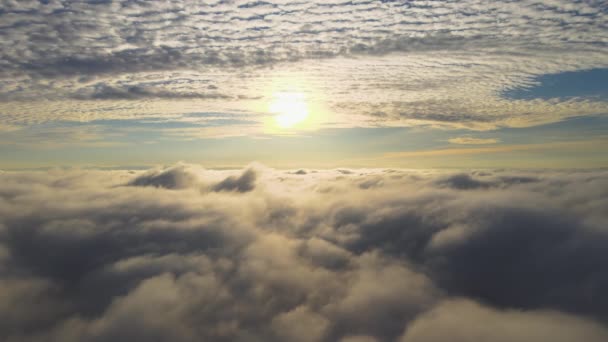 Vista aérea del vibrante amanecer amarillo sobre densas nubes blancas con cielo azul sobre la cabeza. - Imágenes, Vídeo