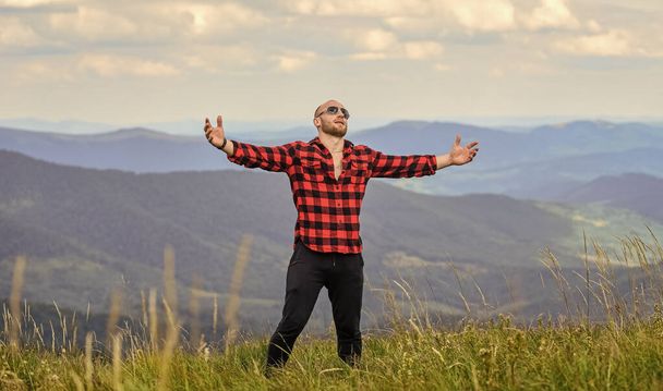 powerful and free. cowboy outdoor. man on mountain landscape. camping and hiking. countryside concept. farmer on rancho. travelling adventure. hipster fashion. sexy macho man in checkered shirt - Photo, Image