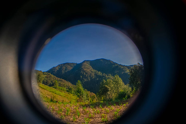 circle with landscape in the middle of field with mountains - Photo, Image