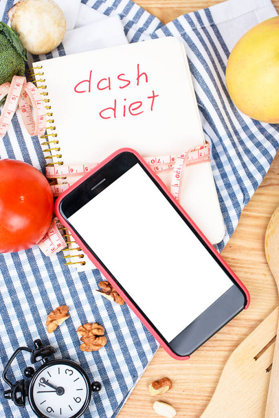 Kulinarischer Blog, Rezeptvorlage, Online-Kochkurse. Telefon mit weißer Attrappe, verschiedenen Küchen- und Kochutensilien auf blauem Hintergrund. - Foto, Bild