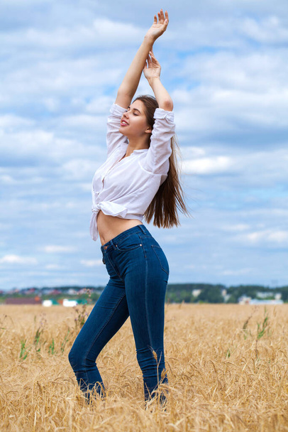 Young happy woman in blue jeans - 写真・画像