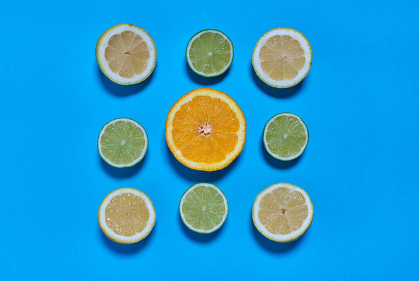Orangen-, Limetten- und Zitronenscheiben auf blauem Hintergrund. CITRUS CITRIC - Foto, Bild