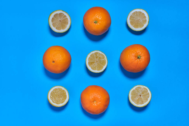 Целые и разделенные апельсины на синем фоне. ЦИТРУС СИТРИК - Фото, изображение