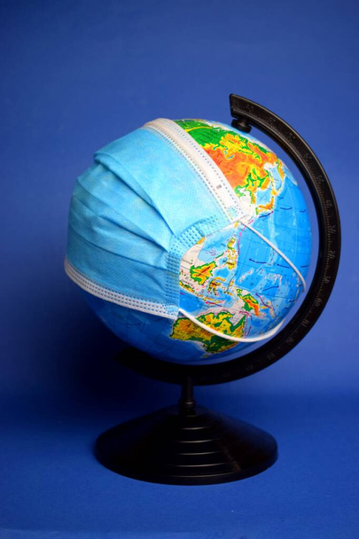 Globus w masce. Koncepcja pandemii koronawirusów - Zdjęcie, obraz