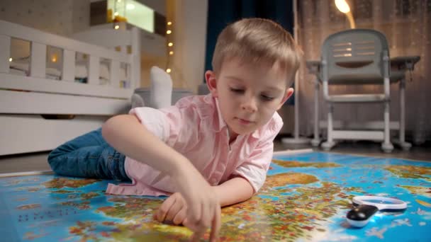 Πορτρέτο του χαριτωμένο μικρό αγόρι με τα δάχτυλα σε όλο το μεγάλο παγκόσμιο χάρτη. Έννοια του ταξιδιού, του τουρισμού και της εκπαίδευσης των παιδιών. Παιδική εξερεύνηση και ανακαλύψεις. - Πλάνα, βίντεο