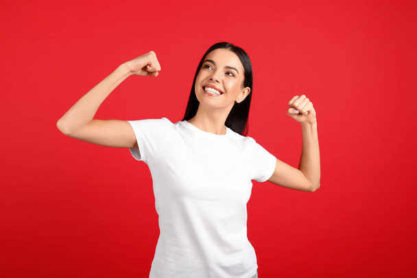 Strong woman as symbol of girl power on red background. 8 March concept - Foto, imagen