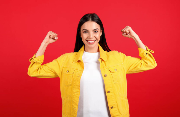Strong woman as symbol of girl power on red background. 8 March concept - Foto, Imagem