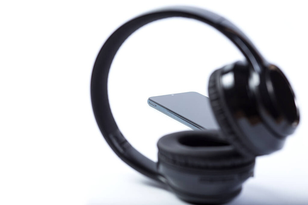 Für Musik hörende Kopfhörer und Mobiltelefone isoliert auf einem weißen. - Foto, Bild