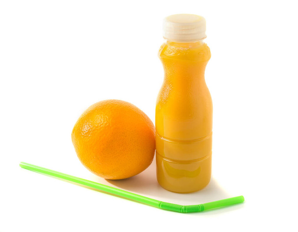 botella con zumo de naranja y una naranja, pajitas que yacen cerca, aislado sobre fondo blanco, comida saludable. espacio de copia. - Foto, Imagen
