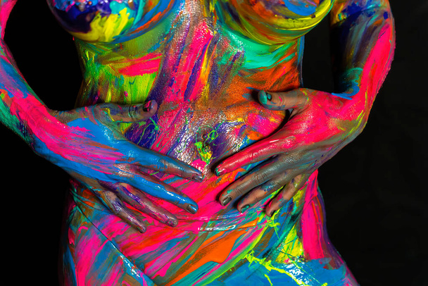 A naked woman is painted with colorful paint in a home environment - Valokuva, kuva