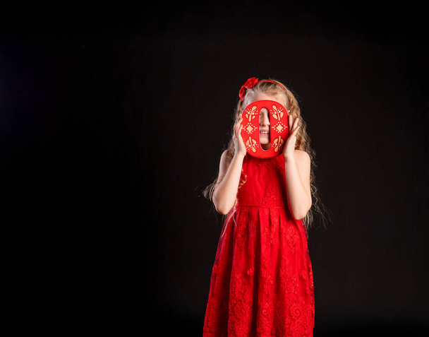 O holds a child holding in his hand the letter LOVE happy red, Valentines Day, on the floor of the heart space. Form banner. love forever, joy in red girl dress, barefoot - Fotografie, Obrázek
