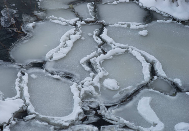 Planchers de glace avec bord de neige dans la rivière sombre - Photo, image