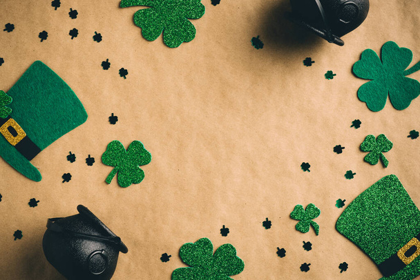 Happy Saint Patrick's Day concept. Flatlay composition with green leprechauns hats, shamrock clover leaves on kraft paper background. Flat lay, top view. Vintage, retro style. - Foto, Imagen