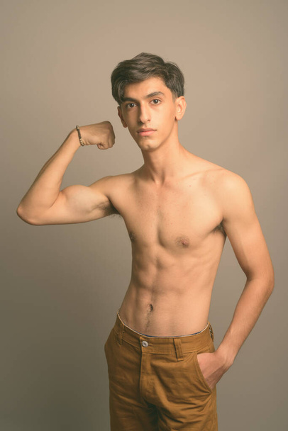 Joven guapo adolescente persa sin camisa sobre fondo gris - Foto, imagen