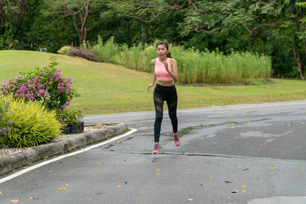 Krásná mladá žena sportovní oblečení jogging v parku. Žena sportovci je cvičení, aby se dobře starat o své zdraví. - Fotografie, Obrázek