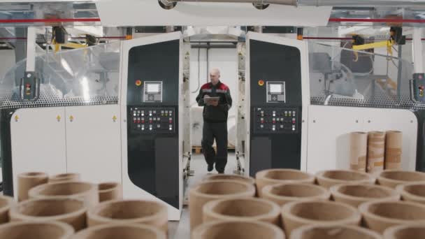 Медленная съемка рабочего процесса управления процессом производства спиральных картонных труб на промышленном заводе - Кадры, видео