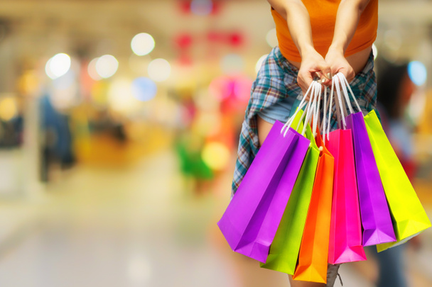 Femme tenant des sacs à provisions colorés sur le fond des centres commerciaux. bonheur, consumérisme, vente et concept de personnes. - Photo, image
