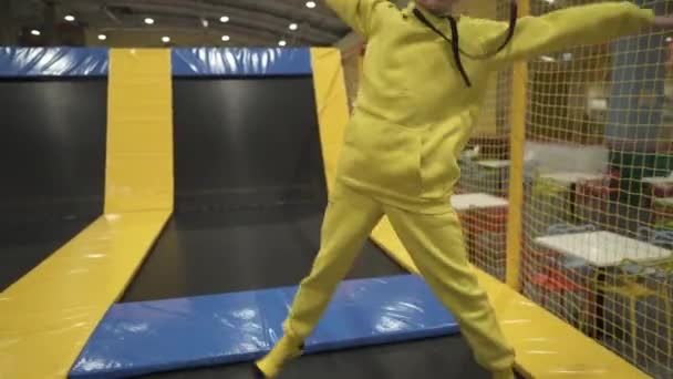 Cute twin brother and sister jumping and bouncing on indoor trampoline together when spending time in children play center. Sports and entertainment concept. Childrens sports and hobbies - Footage, Video