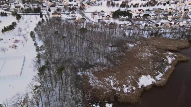 Veduta aerea verso il basso su case singole coperte e strade durante la stagione invernale cortili innevati - Filmati, video