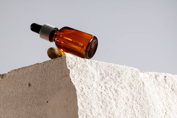 Glass bottle with cosmetic oil on cinder block - Foto, afbeelding