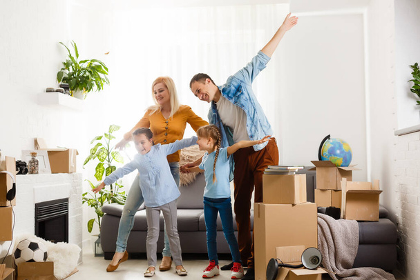 Счастливая семья переезжает домой с коробками - Фото, изображение