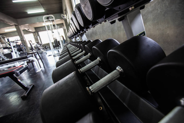 Рядок великого гантелі в фітнес тренажерному залі концепції спортивного фону
 - Фото, зображення