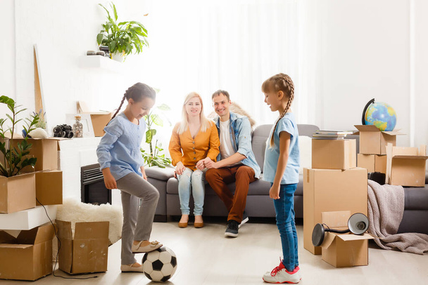 Familia feliz mudándose a casa con cajas alrededor - Foto, Imagen