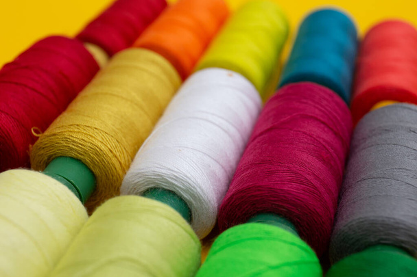 Цветные нити для шитья на желтом фоне - Фото, изображение