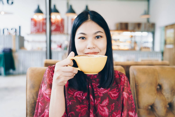 Beautiful asian women hold hot latte art coffe cup sitting in cafe Business women - Zdjęcie, obraz