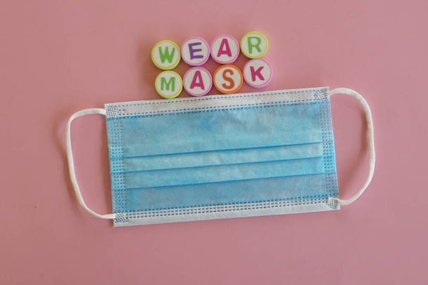 drie lagen gezichtsmasker op roze achtergrond - Foto, afbeelding