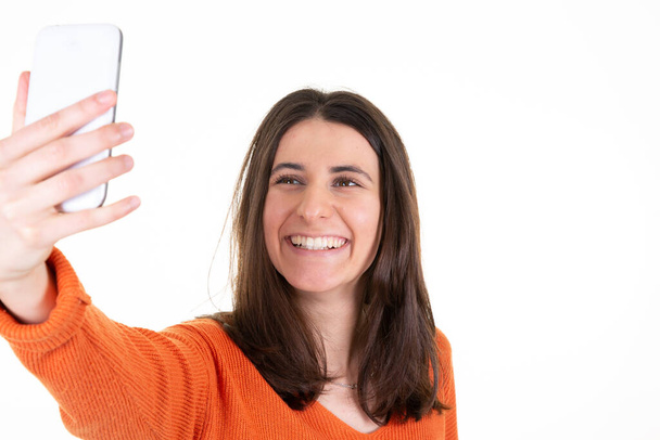 jonge vrouw over geïsoleerde witte achtergrond maken telefoon selfie met mobiele telefoon - Foto, afbeelding