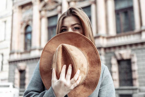 La mujer se cubrió la cara con un sombrero de fieltro. Foto de moda de una joven atractiva - Foto, Imagen